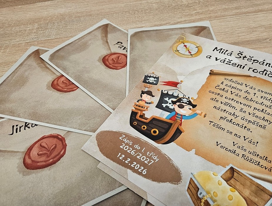Detailní záběr na pozvánky s pirátskou tématikou s hravými pirátskými ilustracemi, kompasem a voskovými pečetěmi. Na některých kartách jsou ručně psaná jména, zatímco hlavní karta obsahuje tištěný text v češtině.